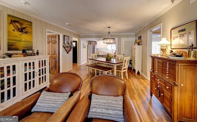 dining room featuring a notable chandelier, crown molding, and light hardwood / wood-style floors