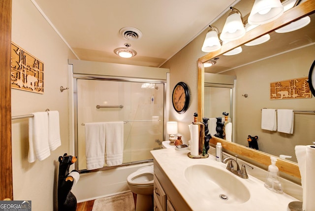 full bathroom featuring vanity, enclosed tub / shower combo, and toilet