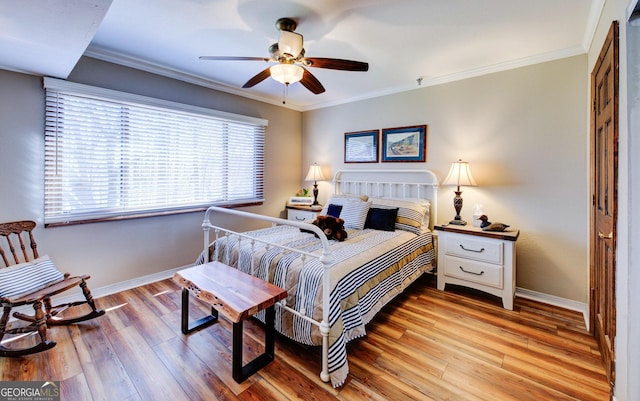 bedroom featuring crown molding, light hardwood / wood-style floors, and ceiling fan