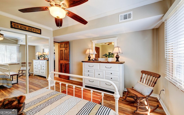 living area featuring crown molding, light hardwood / wood-style floors, and ceiling fan