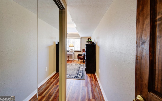 hall featuring dark wood-type flooring and a textured ceiling