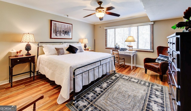 bedroom with hardwood / wood-style flooring, ornamental molding, and ceiling fan