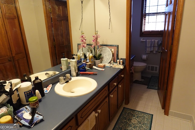 bathroom with toilet, tile patterned flooring, visible vents, and vanity