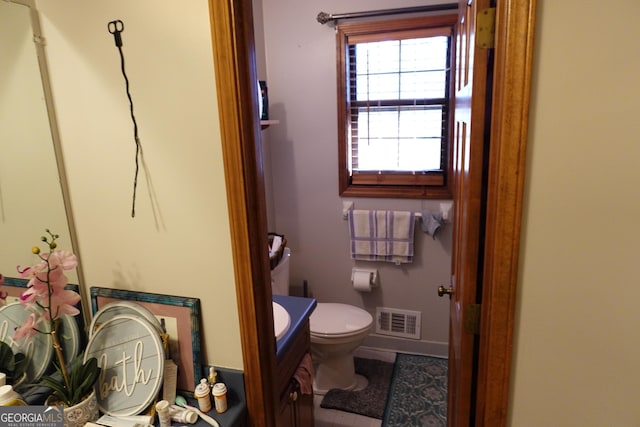 bathroom with baseboards, visible vents, vanity, and toilet