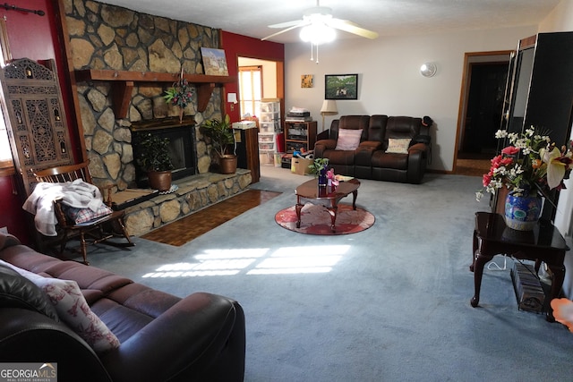 carpeted living room featuring ceiling fan and a fireplace