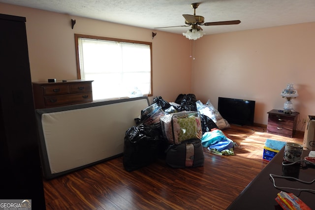 bedroom with ceiling fan, a textured ceiling, and wood finished floors