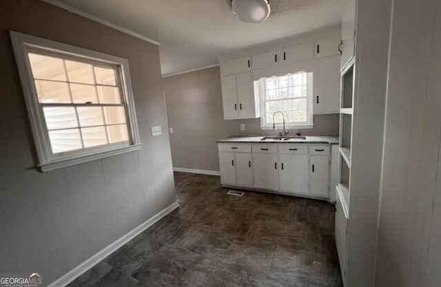 kitchen featuring ornamental molding, sink, and white cabinets