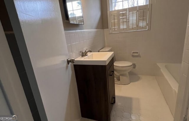 bathroom featuring vanity, plenty of natural light, tile walls, and a bathtub