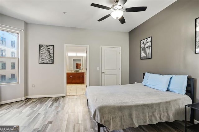 bedroom with connected bathroom, light hardwood / wood-style floors, and ceiling fan