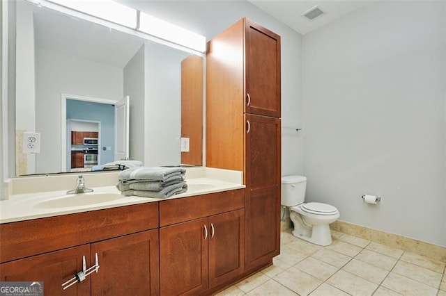 bathroom with tile patterned flooring, vanity, and toilet