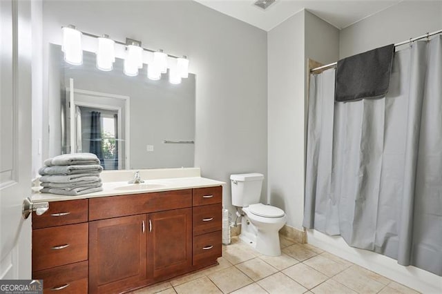 full bathroom featuring vanity, tile patterned floors, toilet, and shower / bath combo with shower curtain