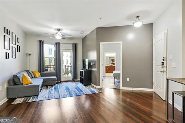 living room featuring dark wood-type flooring and ceiling fan