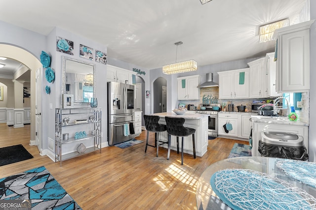 4901 Planters Walk, Douglasville, GA 30135 - kitchen with wall chimney exhaust hood, white cabinetry, decorative light fixtures, a center island, and stainless steel appliances
