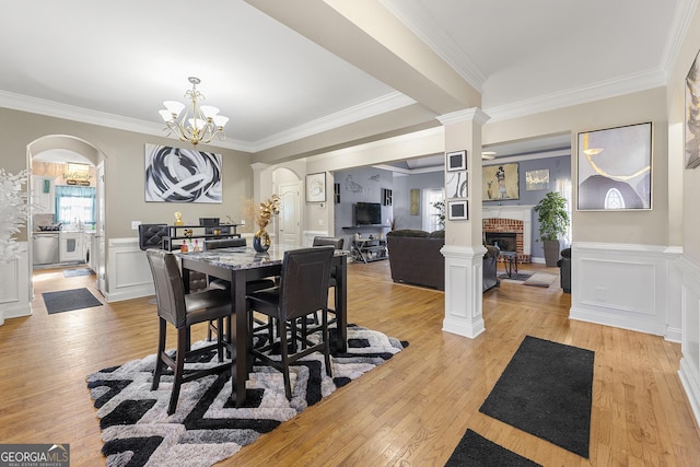 4901 Planters Walk, Douglasville, GA 30135 - dining room with ornate columns, a fireplace, a chandelier, light hardwood / wood-style floors, and crown molding