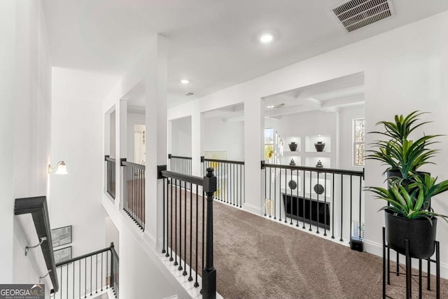 hallway featuring beamed ceiling, coffered ceiling, and carpet floors