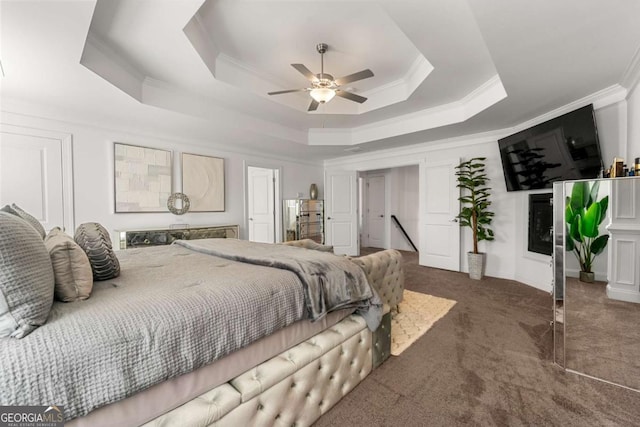 carpeted bedroom featuring crown molding, ceiling fan, and a tray ceiling