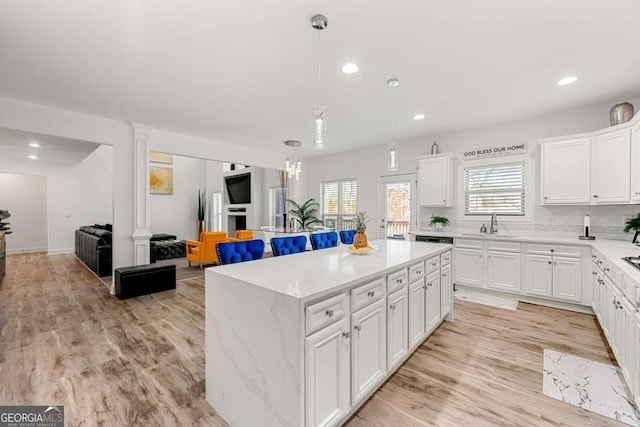 kitchen with light hardwood / wood-style floors, a center island, and white cabinets