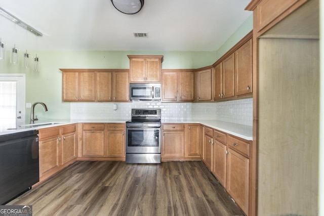 kitchen featuring dark hardwood / wood-style flooring, sink, tasteful backsplash, and stainless steel appliances