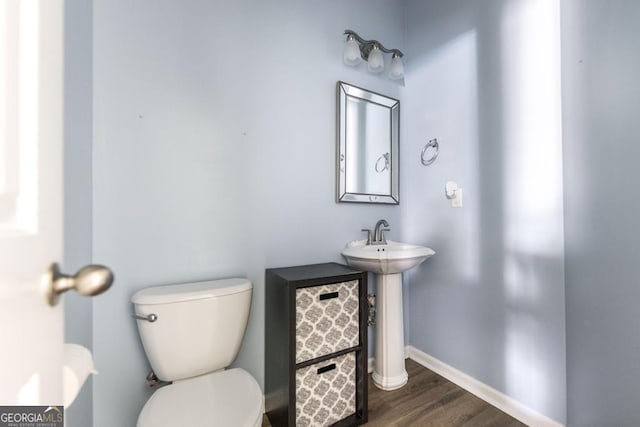 bathroom featuring wood-type flooring and toilet