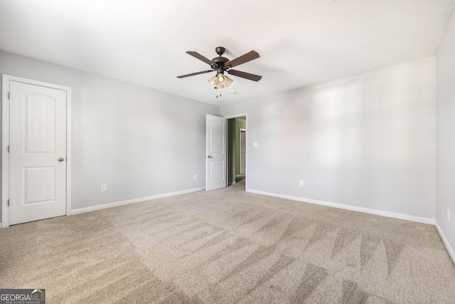 empty room featuring ceiling fan and carpet