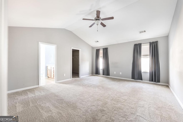 carpeted empty room featuring vaulted ceiling and ceiling fan