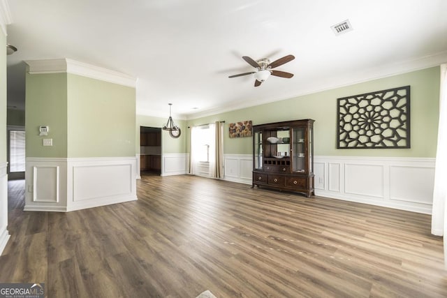 unfurnished living room featuring ceiling fan, ornamental molding, and dark hardwood / wood-style floors