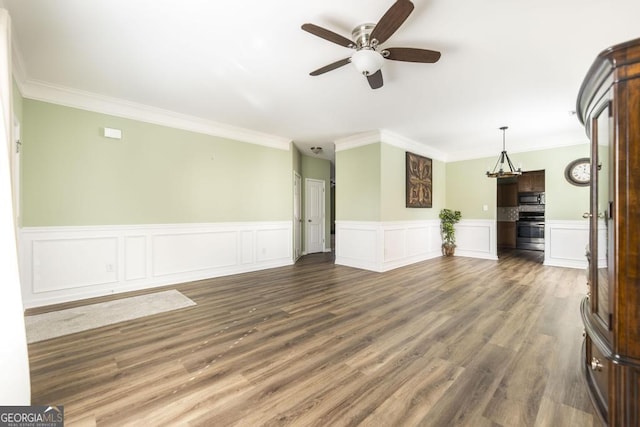 unfurnished living room with ornamental molding, dark wood-type flooring, and ceiling fan