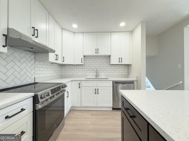 kitchen featuring backsplash, stainless steel appliances, hanging light fixtures, and white cabinets