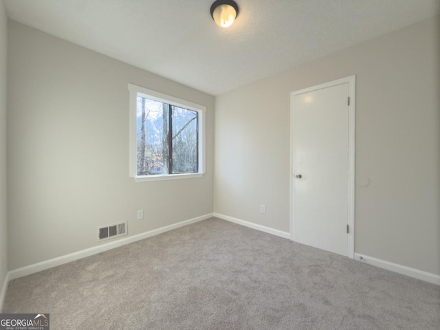 carpeted spare room with a textured ceiling