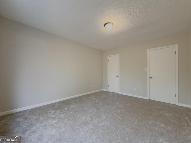 carpeted empty room with a textured ceiling