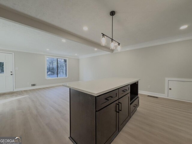 spare room with beam ceiling, crown molding, and light wood-type flooring