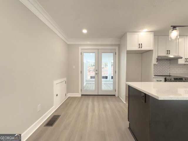 kitchen with crown molding, decorative light fixtures, light hardwood / wood-style flooring, a kitchen island, and beam ceiling