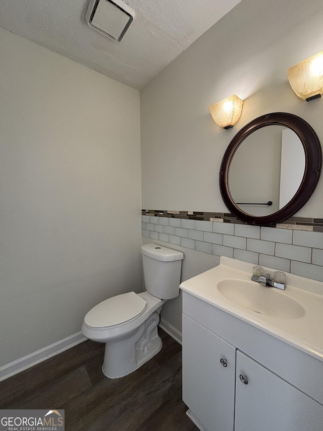 bathroom featuring tile walls, hardwood / wood-style floors, vanity, a textured ceiling, and toilet