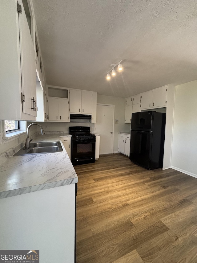 kitchen featuring white cabinets, sink, hardwood / wood-style floors, and black appliances