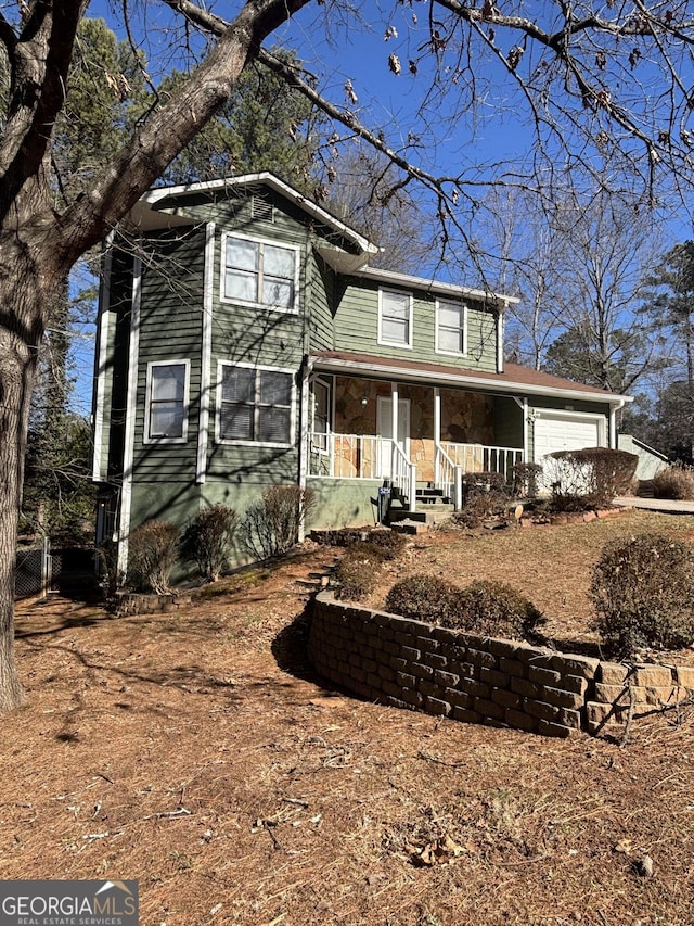 view of property featuring a garage and a porch