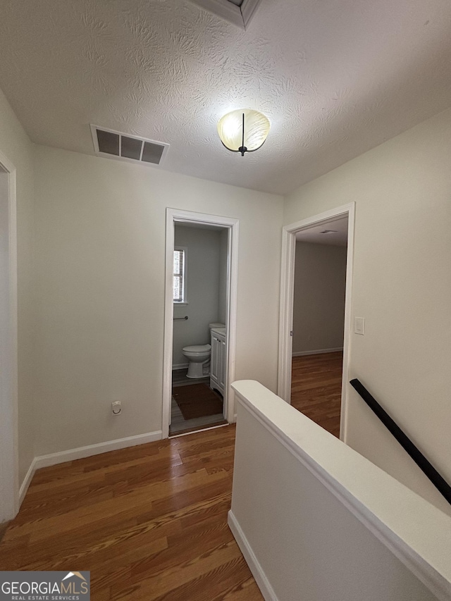 hallway featuring dark hardwood / wood-style floors and a textured ceiling