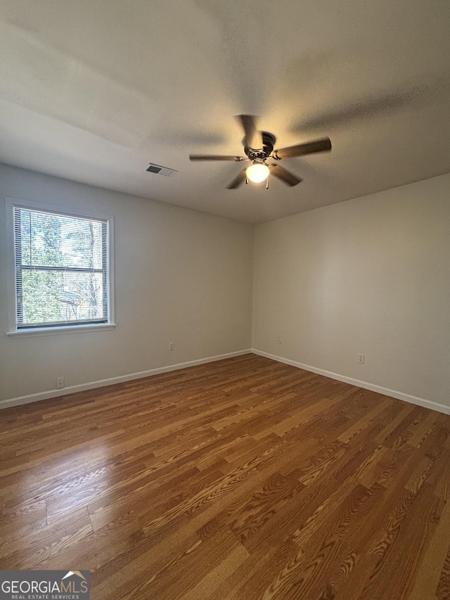 spare room with a textured ceiling, dark wood-type flooring, and ceiling fan