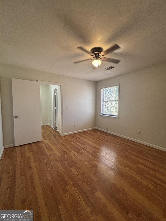 empty room with ceiling fan, hardwood / wood-style floors, and a textured ceiling