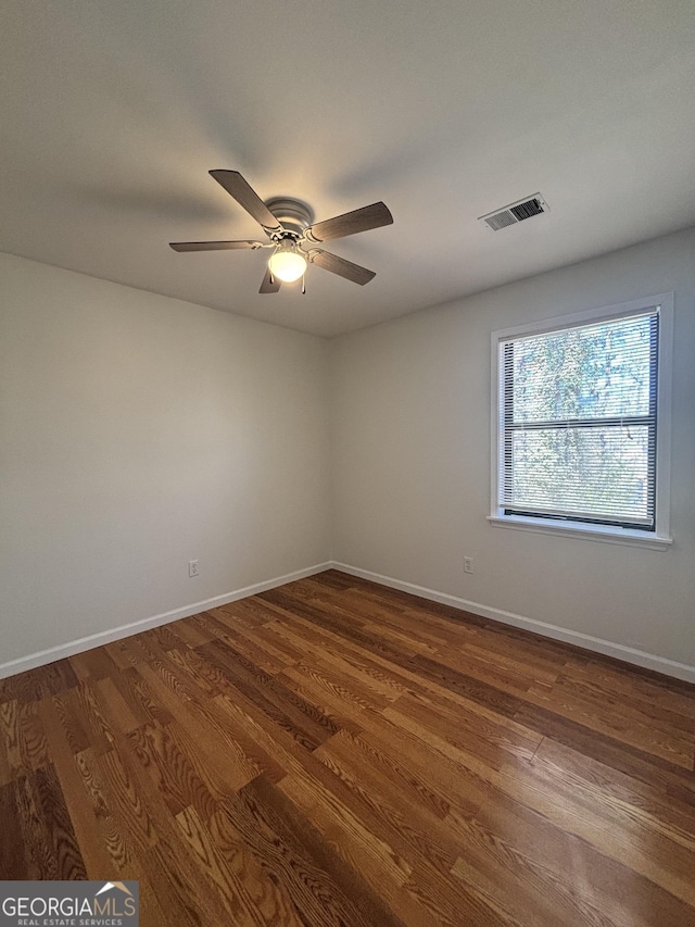 empty room with dark wood-type flooring and ceiling fan