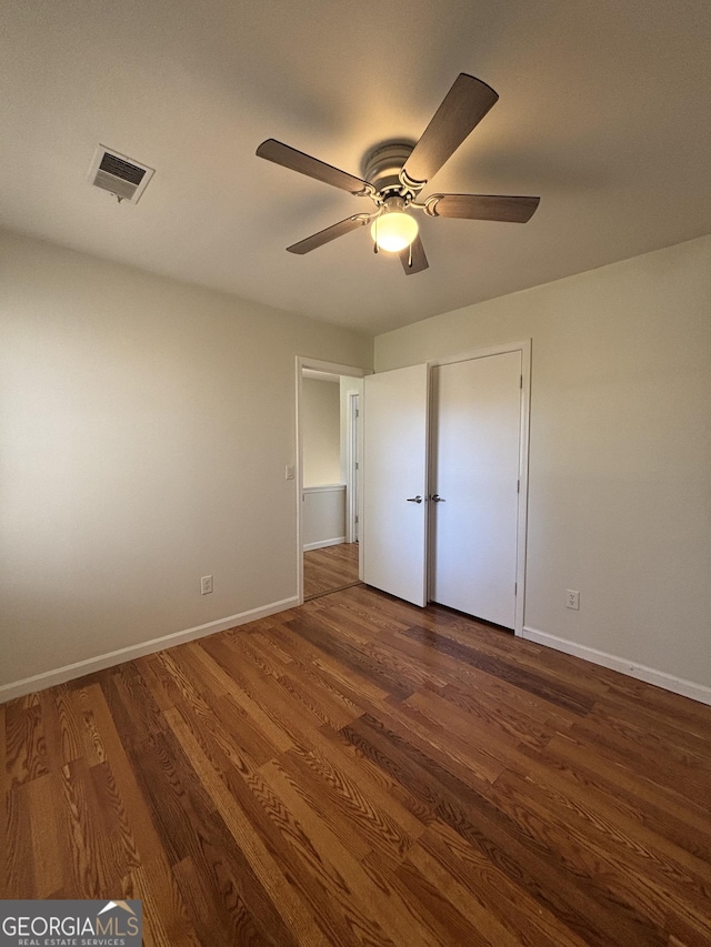 unfurnished bedroom with dark hardwood / wood-style flooring and ceiling fan