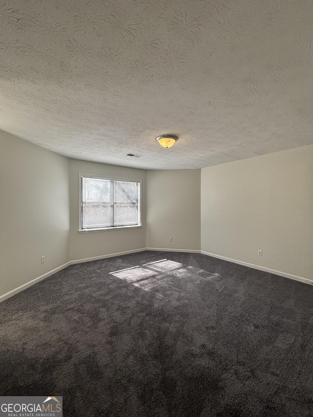 unfurnished room featuring a textured ceiling and carpet