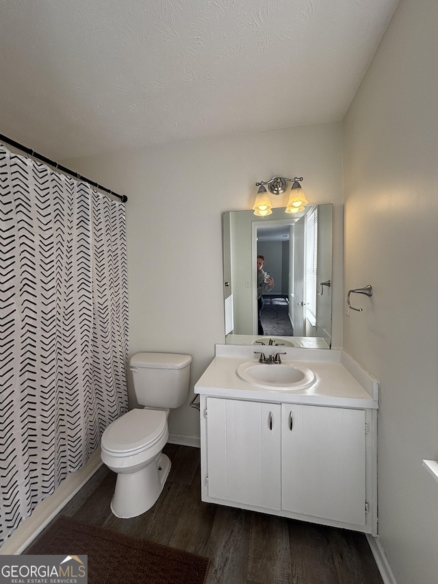 bathroom with vanity, toilet, curtained shower, and hardwood / wood-style floors