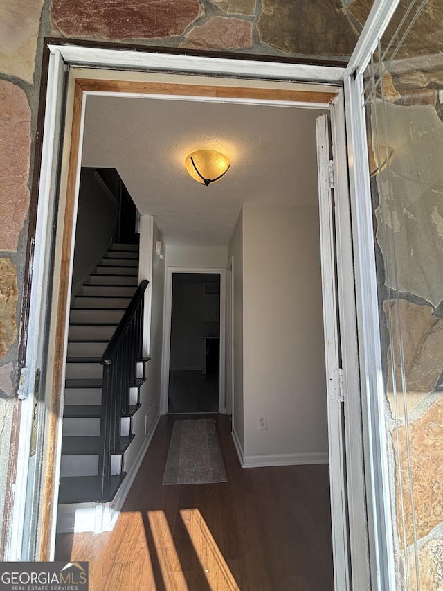 hallway featuring dark hardwood / wood-style floors and a textured ceiling