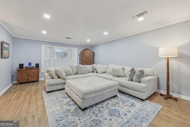 living room with ornamental molding and light hardwood / wood-style floors