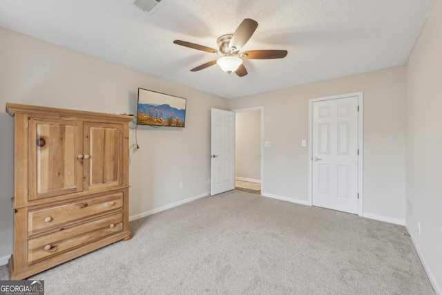 unfurnished bedroom with light carpet, ceiling fan, and a textured ceiling