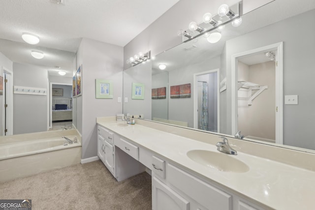 bathroom featuring vanity, a bathtub, and a textured ceiling