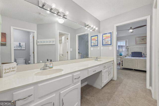 bathroom with vanity, a textured ceiling, and toilet