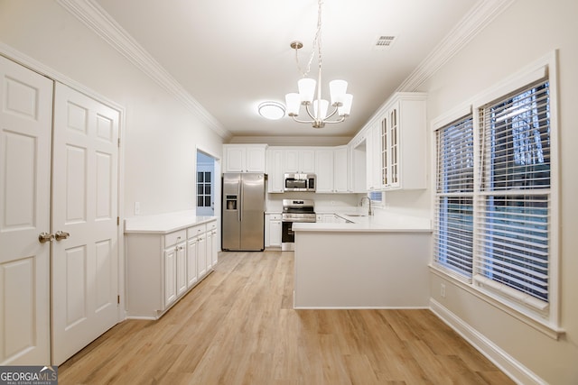 kitchen with sink, decorative light fixtures, appliances with stainless steel finishes, kitchen peninsula, and white cabinets