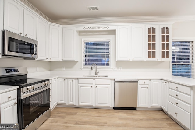 kitchen with white cabinetry, sink, stainless steel appliances, and light wood-type flooring