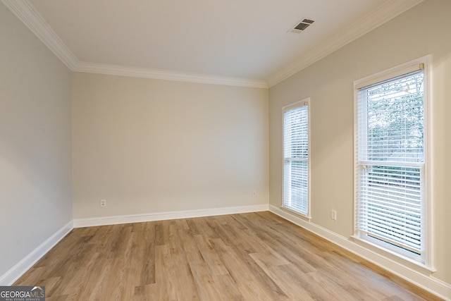 spare room with ornamental molding and light hardwood / wood-style flooring